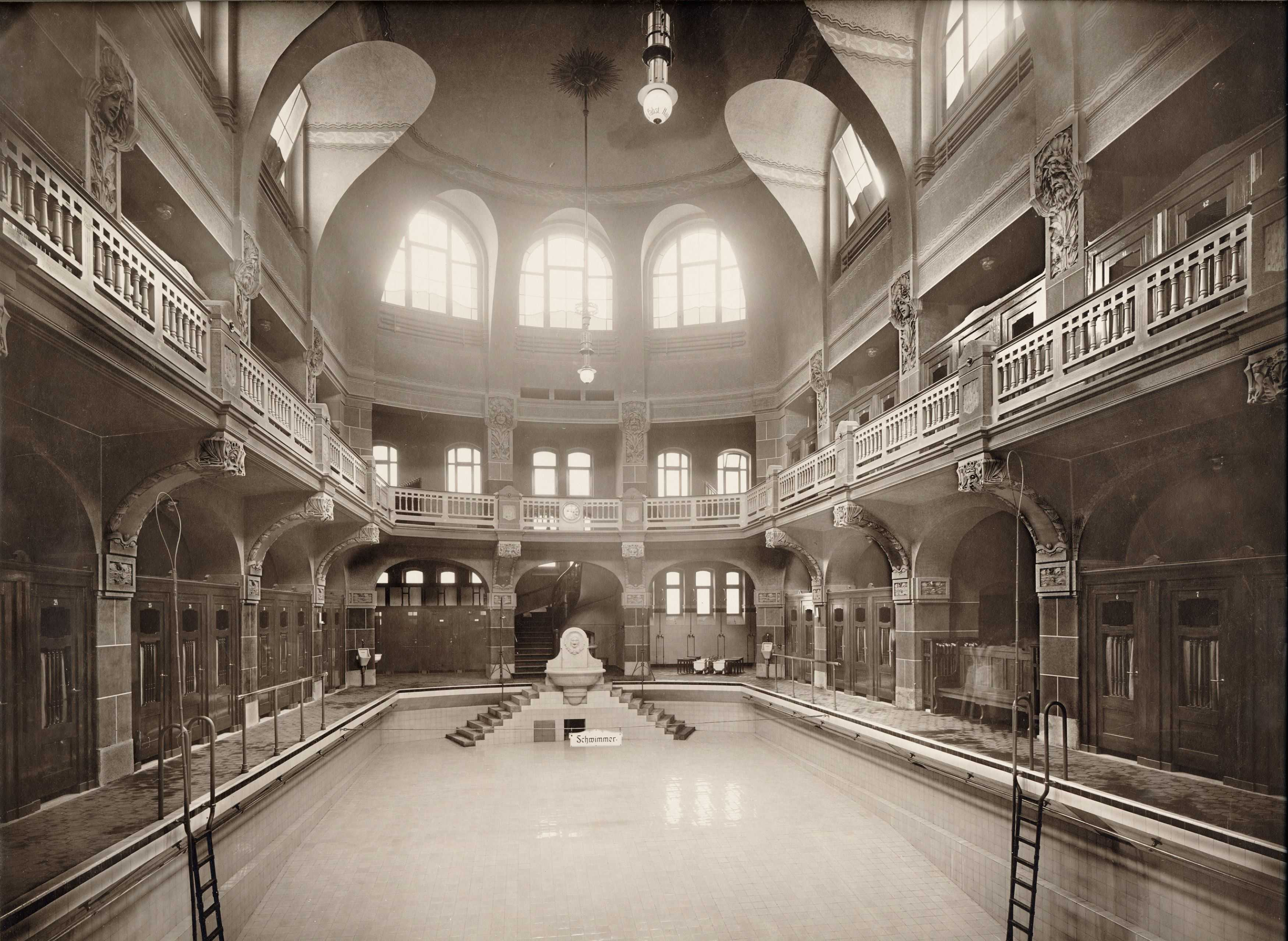 Die städtische Badeanstalt war ein Prestigeprojekt. Das zeigt sich auch in der beeindruckenden Architektur und Ausstattung. Neben den Schwimm- und Badeanlagen gab es einen Friseursalon, eine Gaststätte und sogar ein Hundebad. Für das Publikum wurde der Zugang streng geregelt: Es gab eine Frauen- und eine Männerabteilung. Die Becken für die Männer waren noch einmal nach sozialen Schichten in die I. und II. Klasse unterteilt. Das Männerbecken der I. Klasse war mit 404 qm damals das größte Schwimmbecken im Deutschen Reich.