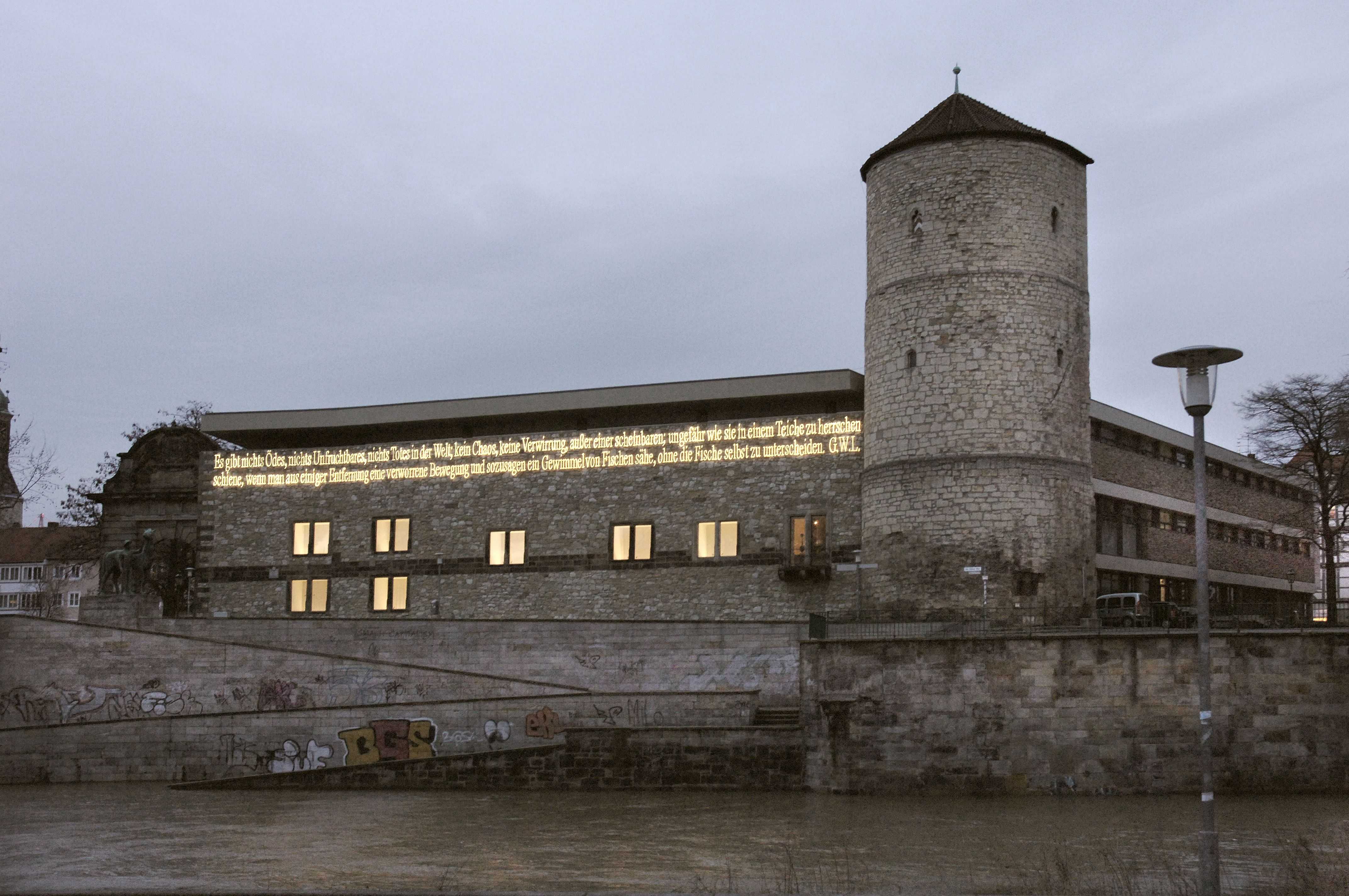 Im Jahr 2000 wurde an der Außenfassade eine Lichtinstallation von Joseph Kosuth angebracht. Das leuchtende Zitat von Leibniz lautet: „Es gibt nicht Ödes, nichts Unfruchtbares, nichts Totes in der Welt, kein Chaos, keine Verwirrung, außer einer scheinbaren, ungefähr wie sie in einem Teiche zu herrschen schiene wenn man aus einiger Entfernung eine verworrene Bewegung und sozusagen ein Gewimmel von Fischen sähe, ohne die Fische selbst zu unterscheiden.“