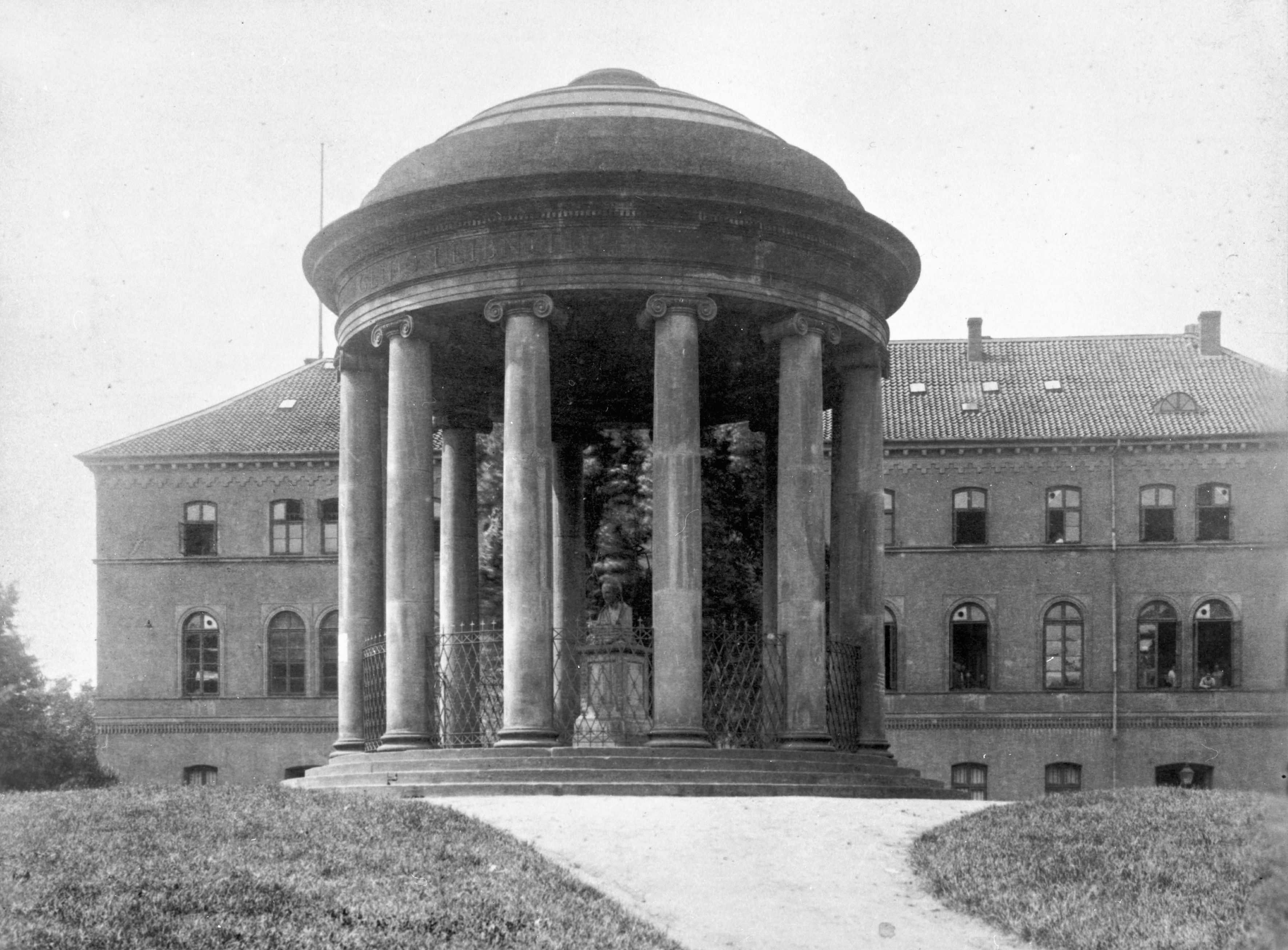 In der Mitte des Denkmals war ursprünglich eine Porträtbüste von Gottfried Wilhelm Leibniz aufgestellt, die der Bildhauer Christopher Hewetson im Jahr 1790 fertiggestellt hatte. Leibniz, geboren 1646, kam um 1676 nach Hannover und schätzte die Stadt gut 40 Jahre lang bis zu seinem Tod 1716 als Wohnsitz.